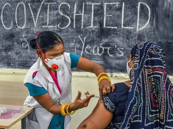 Ajmer_ A medic inoculates a dose of a Covid-19 vaccine to a woman, at a vaccinat....