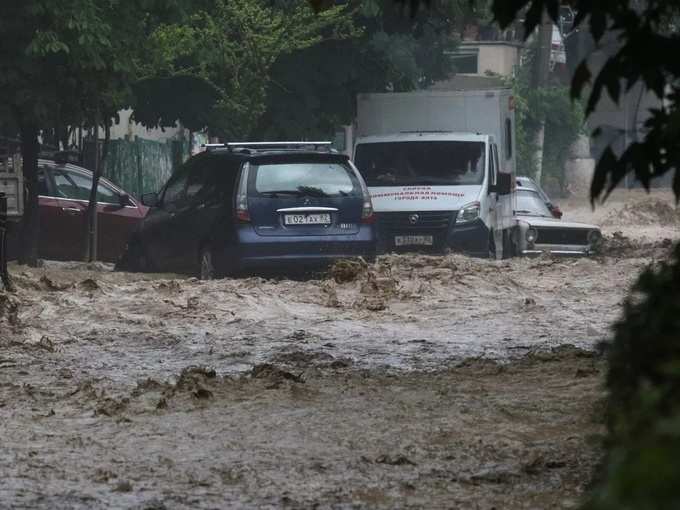 Cars are stuck in deep water in a flooded street following heavy rainfall in Yalta.