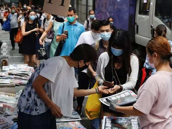 People queue to buy copies of the final edition of Apple Daily, published by Next Digital, in the Central financial district, in Hong Kong.