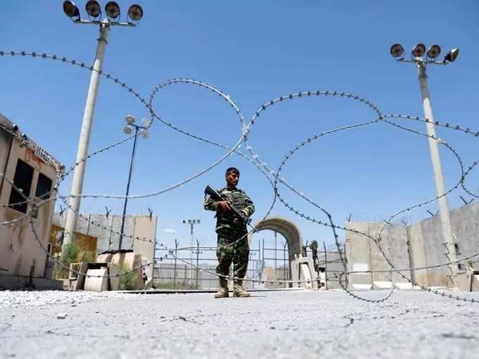 Afghan National Army soldier stands guard at Bagram U.S. air base gate on day of troop departure.