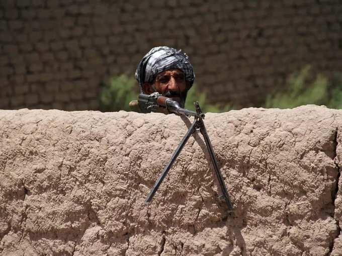 Former Mujahideen keeps watch at a check post as he holds a weapon to support Afghan forces in their fight against Taliban, on the outskirts of Herat province.