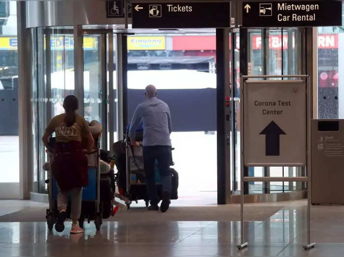 Passengers pass a sign leading to a test center for the coronavirus disease (COVID-19), at Munich International Airport