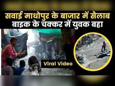 Viral Video: बारिश के बाद बाजार में बहने लगी मोटरसाइकिलें, बचाने के चक्कर में युवक भी बहा