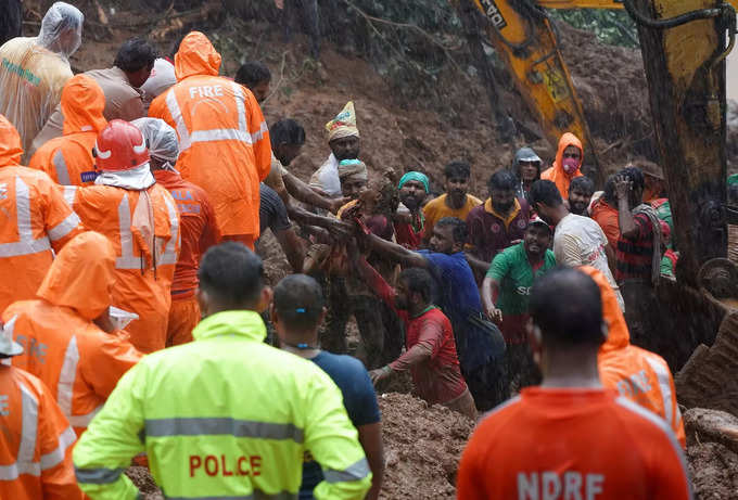 Rescue workers carry the body of a victim after recovering it from the debris of a residential house following a landslide in Kokkayar