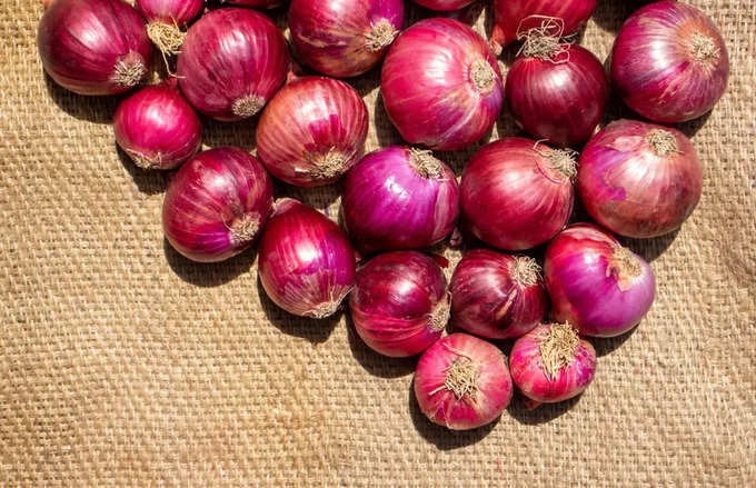 2  Stack of Harvested Onion on Burlap Fabric Background stock photo