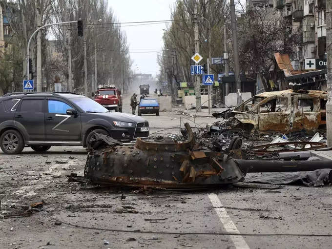 Mariupol _ A part of a destroyed tank and a burned vehicle sit in an area contro....