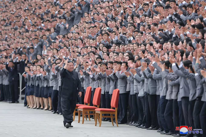 North Korean leader Kim Jong Un waves toward students and young workers during a photo session in Pyongyang