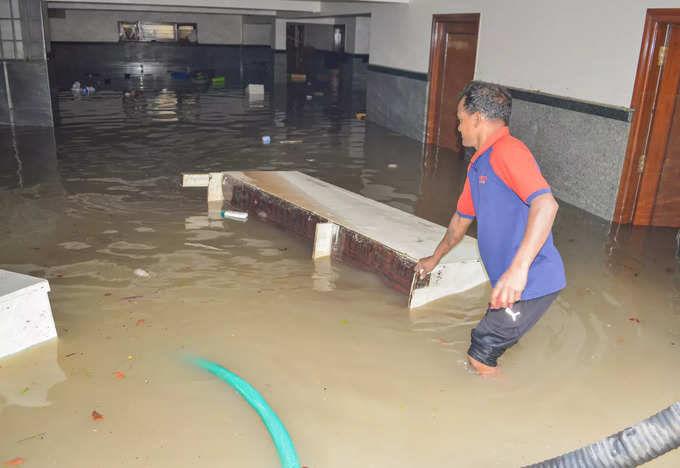 Bengaluru: Residents remove the items from a waterlogged basement of an apartmen...