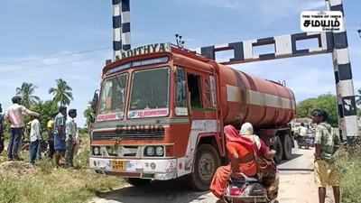 ரயில்வே தடுப்பு கம்பியில் மாட்டிய லாரி; சிரமப்பட்டு மீட்ட டிரைவர்!