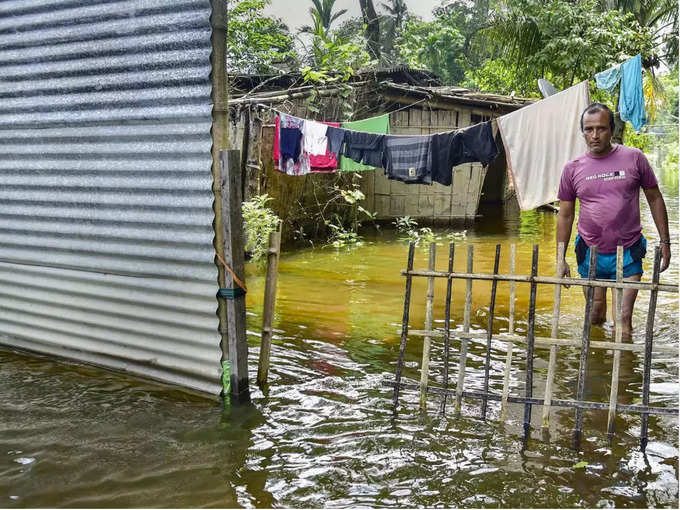 असम में बाढ़ के चलते घरों में कैद लोग