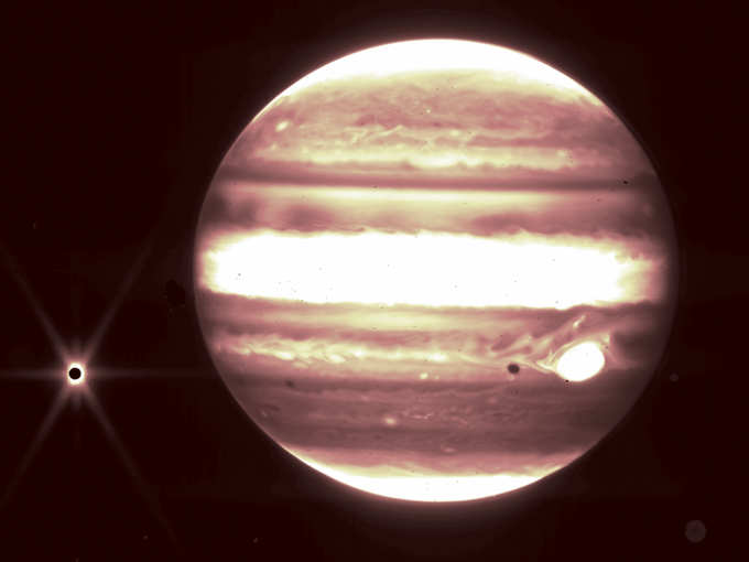 Jupiter, center, and its moon Europa, left, are seen through the James Webb Space Telescope’s NIRCam instrument 2.12 micron filter.