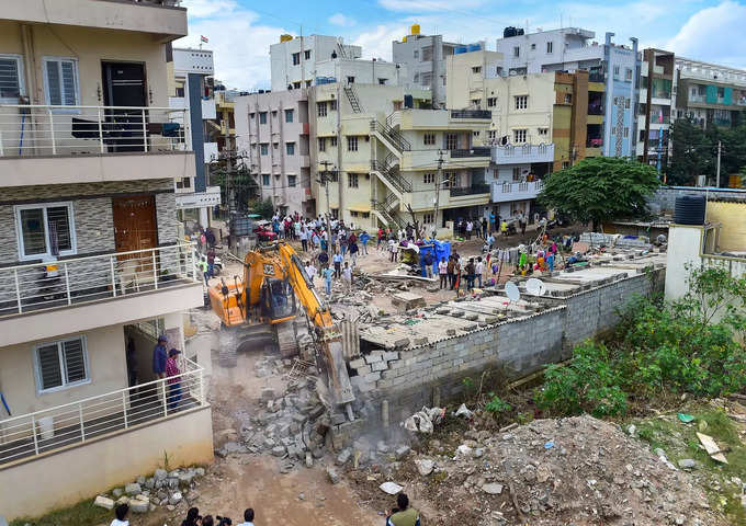 BBMP bulldozer demolishes  illegal structure built on storm-water drain .