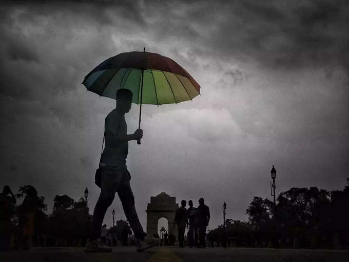 इंडिया गेट के ऊपर छाए काले बादल बता रहे हैं कि अभी बारिश जल्दी थमने वाली नहीं है।