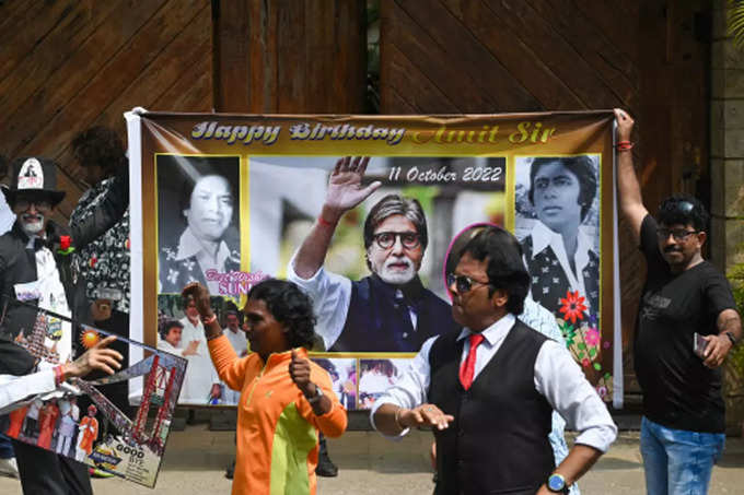 Fans of Amitabh Bachchan dance outside his house