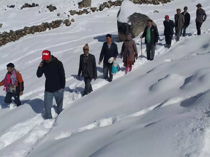 चंबा जिले के पनगी में बर्फ से ढकी सड़क पार करके पहुंचे मतदाता