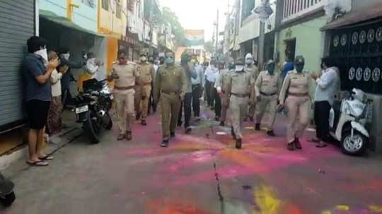 people welcome police flag march with colourful rangoli