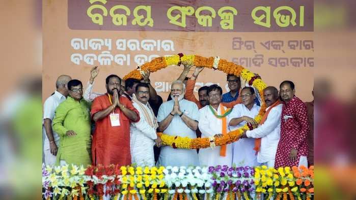 Kalahandi: Prime Minister Narendra Modi garlanded by party workers in the presence of BJP Odisha President Basanta Kumar Panda during 'Vijay Sankalp Samavesh' public meeting ahead of Lok Sabha elections, at Bhawanipatna in Kalahandi, Tuesday, April 02, 2019. (PTI Photo)(PTI4_2_2019_000072B)