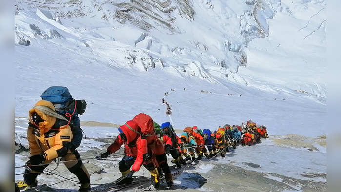 In this May 22, 2019 photo, a long queue of mountain climbers line a path on Mount Everest just below camp four, in Nepal. Seasoned mountaineers say the Nepal government's failure to limit the number of climbers on Mount Everest has resulted in dangerous overcrowding and a greater number of deaths. (AP Photo/Rizza Alee)