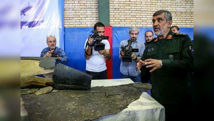 ????????? ??????? ?????? ?????? ??????????????  ????????? ???? ???????? ?????? ???? ???? ??? ???????.  General Amir Ali Hajizadeh (R), Iran's Head of the Revolutionary Guard's aerospace division, speaks to media next to debris from a downed US drone reportedly recovered within Iran's territorial waters and put on display by the Revolutionary Guard in the capital Tehran on June 21, 2019. - Iran's state television broadcast images of what it said was debris from a downed US drone recovered inside its territorial waters. The television broadcast a short clip of a Revolutionary Guards general answering questions in front of some of the debris he said had been recovered after yesterday's missile strike. The downing of the drone -- which Washington insists was over international waters but Tehran says was within its airspace -- has seen tensions between the two countries spike further after a series of attacks on tankers the US has blamed on Iran. (Photo by Meghdad Madadi / TASNIM NEWS / AFP)