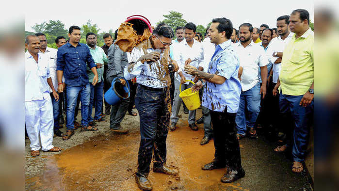 Kankavali: Congress MLA Nitesh Narayan Rane and his supporters throw mud on engineer Prakash Shedekar at a bridge near Mumbai-Goa while they were inspecting the pothole-ridden highway, in Kankavali, Thursday, July 4, 2019. (PTI Photo) (PTI7_4_2019_000163B)