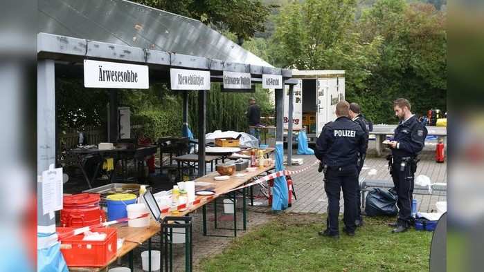 In this Sunday, Sept. 8, 2019 photo police officers investigate a booth after an explosion at a village festival in Freudenberg, Germany. Authorities say 14 people have been injured, five of them with life-threatening burns, during an explosion at a village festival in western Germany. Police told German news agency dpa that it appears likely that oil inside a big frying pan caused the explosion at the local 'Backesfest' (bakery festival) that was attended by about 100 people. (Berthold Stamm/dpa via AP)