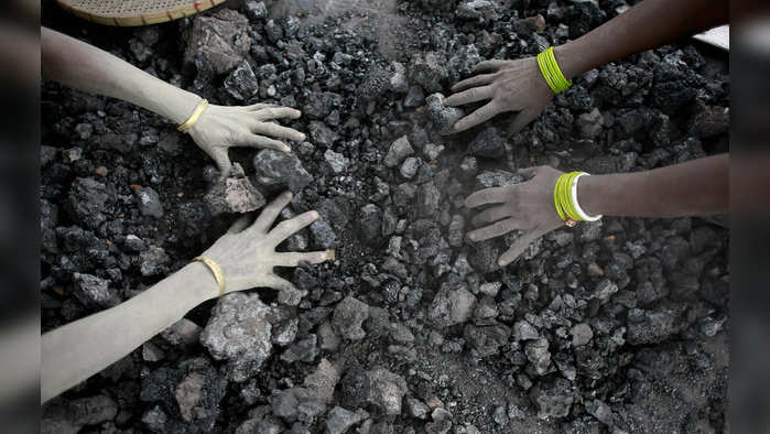 FILE - In this Monday, Dec. 14, 2015, file photo, Indian women use bare hands to pick reusable pieces from heaps of used coal discarded by a carbon factory in Gauhati, India. Inger Andersen, head of the U.N. Environment Program, says the world needs 'quick wins to reduce emissions as much as possible in 2020.' Ahead of a global climate summit in Madrid next week, her agency published a report Tuesday showing the amount of planet-heating gases released into the atmosphere hitting a new high last year. (AP Photo/ Anupam Nath, File)