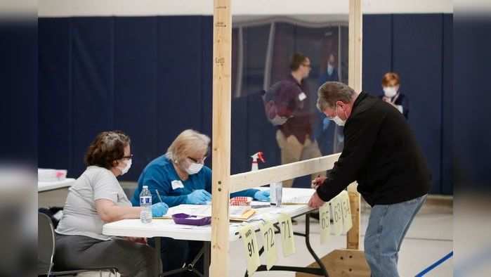 A man checks in to cast his ballot in at a Democratic presidential primary election at the Kenosha Bible Church gym in Kenosha, Wisconsin, on April 7, 2020. - The Wisconsin Supreme Court blocked a last-minute attempt by the governor of the midwestern state to postpone the next day's Democratic presidential primary and other elections because of the coronavirus epidemic and ruled that the vote should go ahead. (Photo by KAMIL KRZACZYNSKI / AFP)