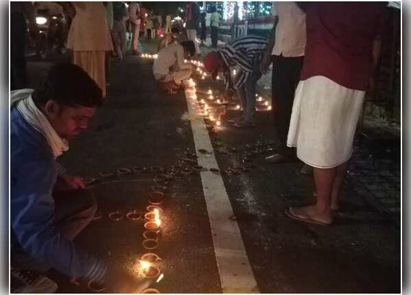 अयोध्या में घरों के बाहर दीप जला रहे लोग