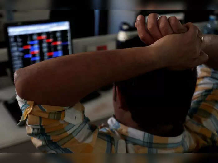 FILE PHOTO: Broker reacts while trading at his computer terminal at a stock brokerage firm in Mumbai