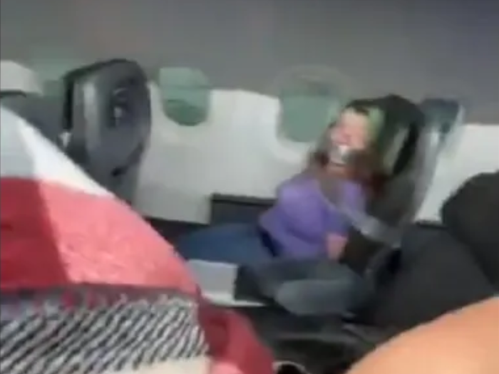 Woman tries to open plane door during mid-flight