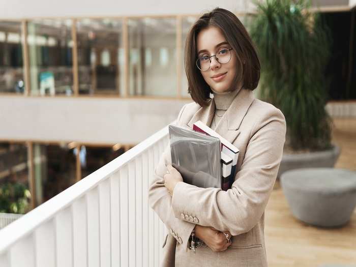 education-business-women-concept-portrait-young-attractive-elegant-female-tutor-young-teacher-student-carry-studying-books-laptop-standing-hall-smiling-camera