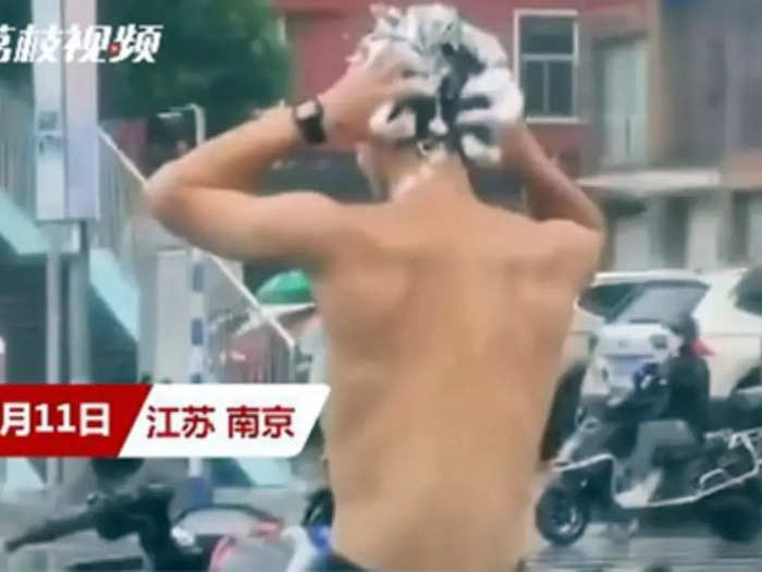 Man washes hair in rain at red light | Image: Lizhi Video