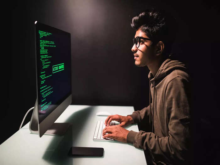 male-indian-programmer-working-desktop-computer-white-desk-office