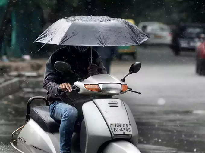 Two-Wheeler rider with umbrella
