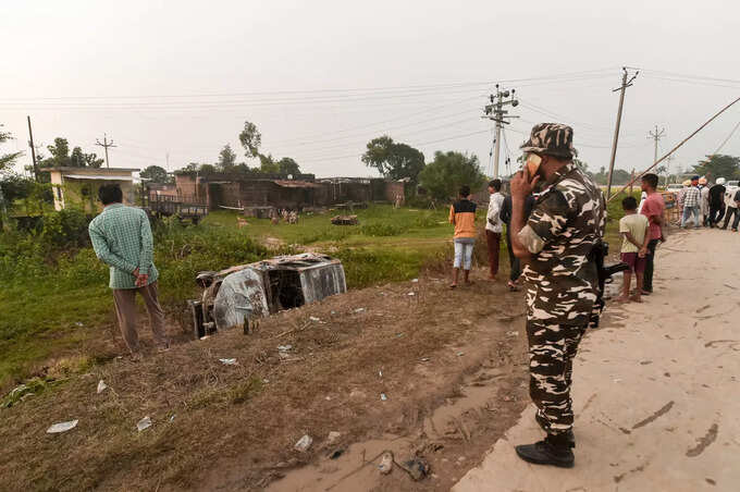 Lakhimpur Kheri: A security personnel stands guard while people take a look at t... Lakhimpur Kheri: A security personnel stands guard while people take a look at t...