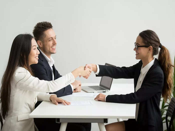 smiling-diverse-businesswomen-shake-hands-group-meeting-deal-concept