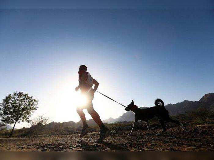 A participant is seen running with his pet during the HK9 Canicross event in Hatta, UAE