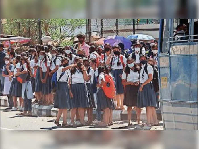 School students wait for bus without maintaining social distancing at High Court Junction in Kochi.