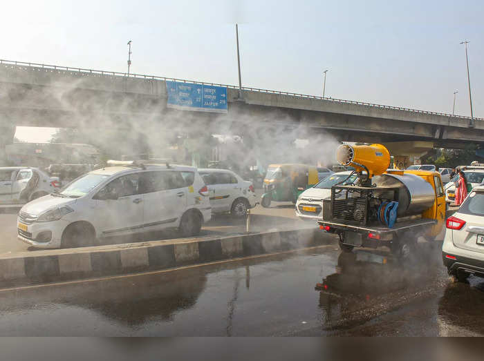 Gurugram: An anti-smog gun sprays water droplets to curb air pollution, at Delhi...