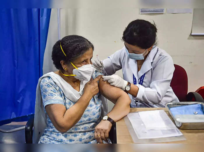New Delhi_ A health worker administers a dose of COVID-19 preventive vaccine to ....