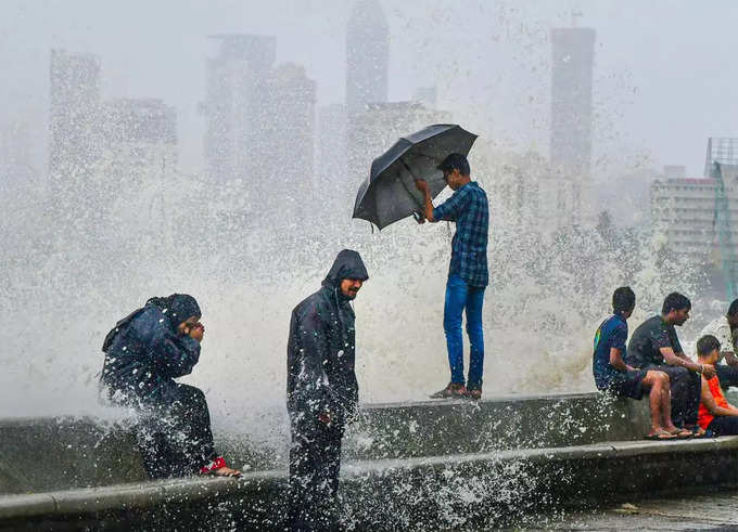 मुंबई के मरीन ड्राइव पर भारी बारिश के बीच जुटे लोग