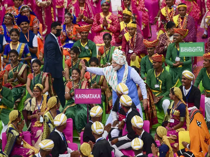 अपने पीएम को पास पाकर  उत्साह में लोग और हाथ हिलाकर अभिवादन स्वीकारते प्रधानमंत्री नरेंद्र मोदी